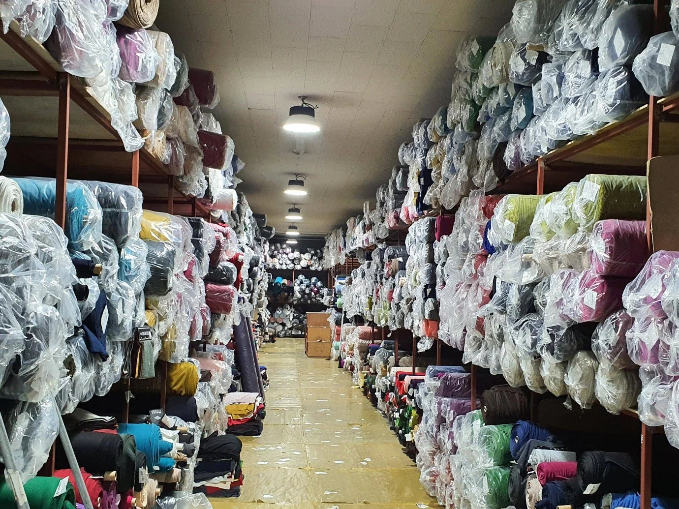 Organized aisles of ready-stock fabric rolls
